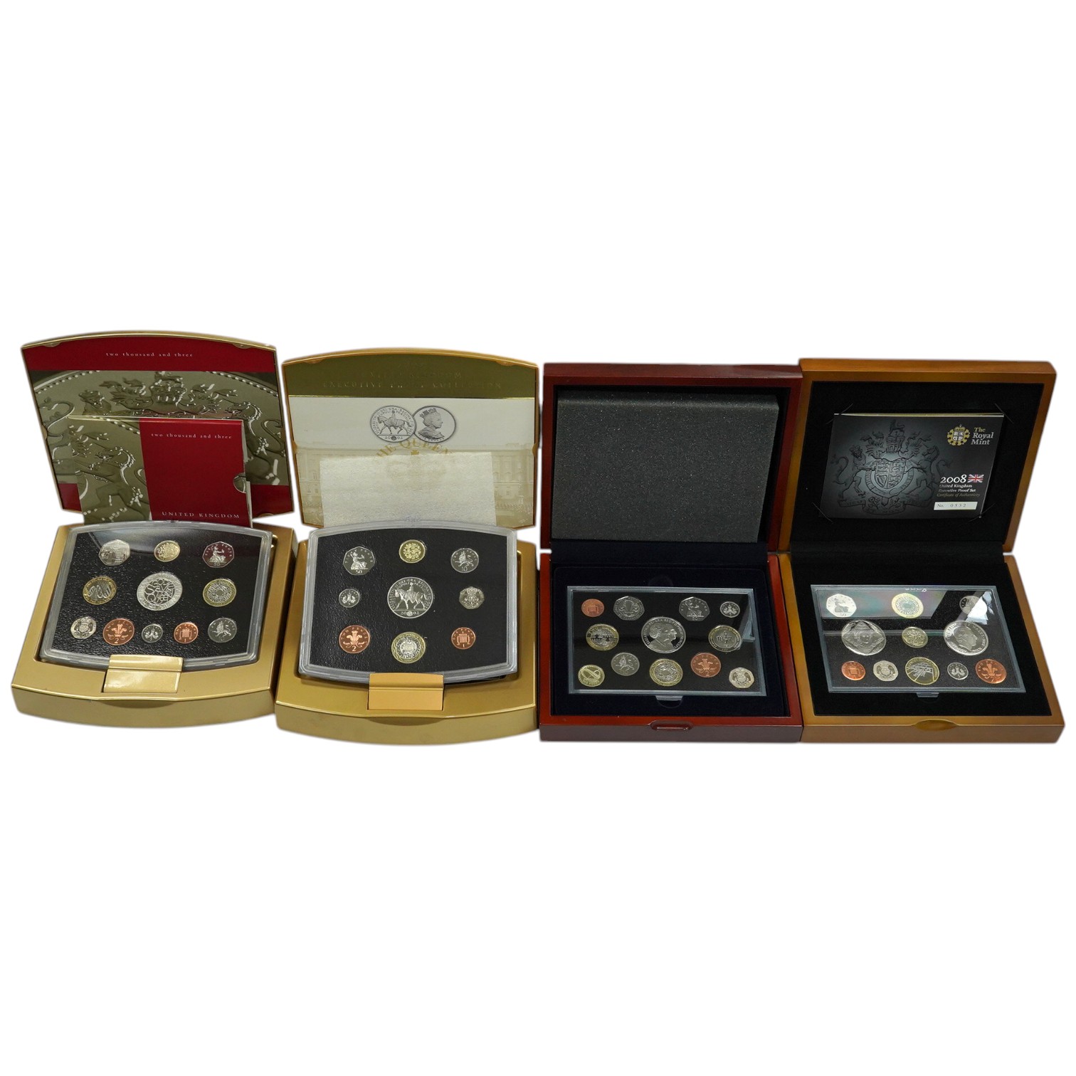 Royal Mint UK QEII coins, four executive proof coin sets, 2002 & 2003 in Golden Jubilee cases with certificates, 2007 & 2008, in wood cases of issue with certificates